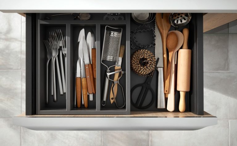 Tiroir de cuisine rempli de couverts et d'ustensiles